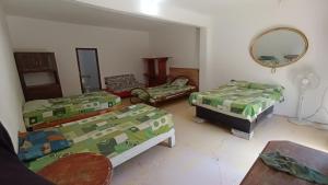 Habitación con 3 camas y espejo. en Casa la jungla, en Miacatlán