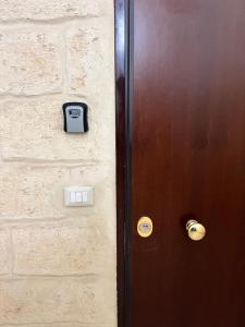 a door with a clock on the side of it at Piazzetta 42 Holiday Room in Trani