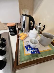 a counter top with a coffee pot and cups on it at Piazzetta 42 Holiday Room in Trani