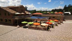 une rangée de tables avec des parasols devant un bâtiment dans l'établissement Villa Ana María Cuenca-Hotel, à Chaullamba