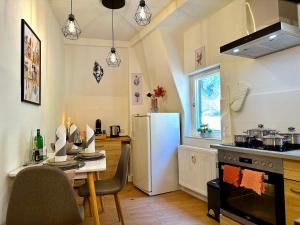 eine Küche mit einem Tisch und einem weißen Kühlschrank in der Unterkunft Boutique Apartment • Zentrum • Netflix • Parkplatz in Bad Schandau