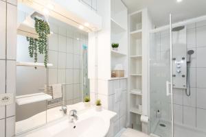 ein weißes Badezimmer mit Waschbecken und Dusche in der Unterkunft Nouveau - Le CityScape - Petite Venise in Colmar