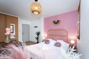 ein Schlafzimmer mit einem weißen Bett mit rosa Wänden in der Unterkunft Nouveau - Le CityScape - Petite Venise in Colmar