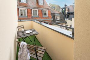 einen Balkon mit einem Holztisch und einer Bank darauf in der Unterkunft Nouveau - Le CityScape - Petite Venise in Colmar