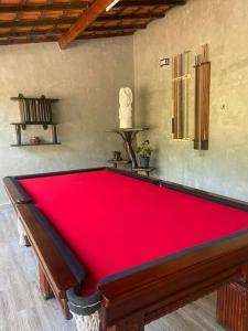 uma grande mesa de bilhar vermelha num quarto em Casa grande no Guarau em Peruíbe