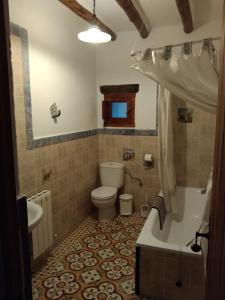 a bathroom with a tub and a toilet and a sink at La Posada del Altozano in Lanteira
