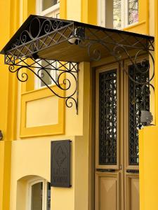 a entrance to a yellow building with a sign on it at Makmani Hotel in Tbilisi City