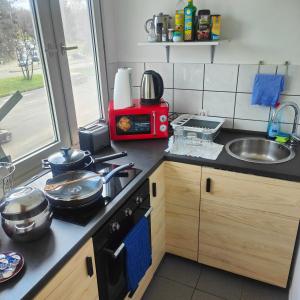 a kitchen with a stove and a sink and a microwave at MO HOME24 in Cologne
