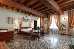 a bedroom with a bed and a table and chairs at Hotel Villa Policreti in Castello dʼAviano