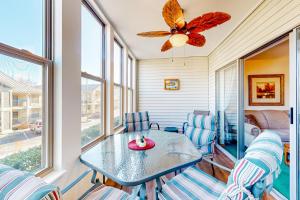 a dining room with a table and chairs and windows at Table Rock Lake Escape in Hollister