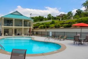 a pool with chairs and tables and a building at Table Rock Lake Escape in Hollister