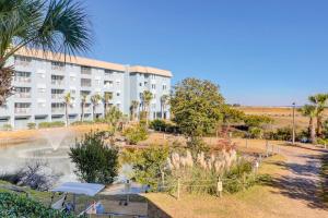 a large white building with palm trees in front of it at Hilton Head Resort 4336 in Hilton Head Island