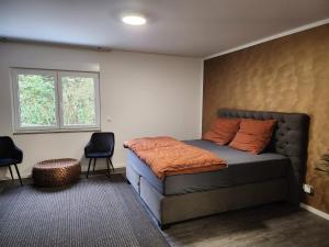 a bedroom with a bed and two chairs and a window at Valley of Business Frankfurt-West - Studio Apartment in Hofheim am Taunus