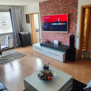 a living room with a flat screen tv on a brick wall at MO HOME24 in Cologne