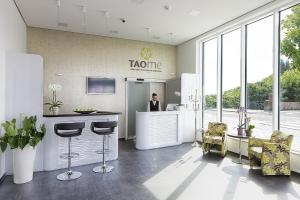 a man standing at a counter in a lobby at Taome Feng Shui Stadthotel Breisgau in Emmendingen