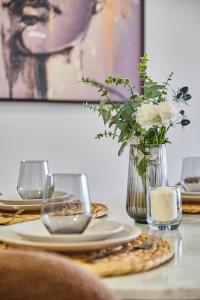 une table avec un vase de fleurs et une assiette de nourriture dans l'établissement Sleek and Modern 2-Bed Unit in Downtown Casa, à Casablanca