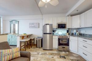 a kitchen with white cabinets and a stainless steel refrigerator at Daytona Beach Club Unit 523 in Daytona Beach