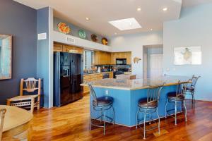 a kitchen with a blue island with bar stools at The Fox Den in Tucson