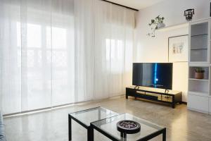 uma sala de estar com uma televisão e uma mesa de vidro em Blue Note Apartment em Montesilvano