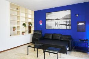 uma sala de estar com um sofá e uma parede azul em Blue Note Apartment em Montesilvano