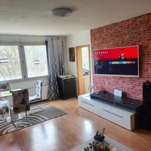 a living room with a large tv on a brick wall at MO HOME24 in Cologne