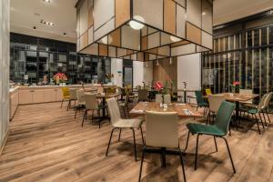 un restaurant avec des tables et des chaises et un grand lustre dans l'établissement Hotel Distrito ZF, à Bogotá