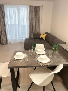 - un salon avec une table, des chaises et un canapé dans l'établissement DA apartments, à Varna