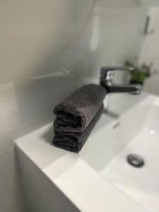 - une serviette assise au-dessus d'un lavabo dans l'établissement DA apartments, à Varna