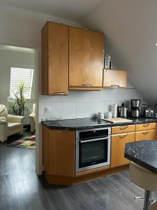 uma cozinha com armários de madeira e um forno com placa de fogão em Wolfenbüttler Apartment em Volfembutel