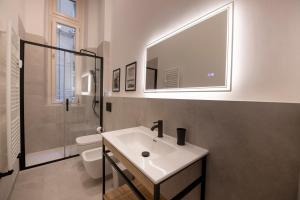 bagno con lavandino, servizi igienici e specchio di 227 - Largo Zecca Luxury Apartment - Nel cuore del centro di Genova a Genova