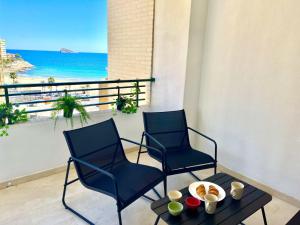 2 Stühle und ein Tisch auf einem Balkon mit Meerblick in der Unterkunft Paradise Home By Gloove in Villajoyosa