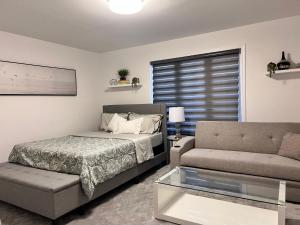 a bedroom with a bed and a couch at Spacious 4-Bedroom Home, Comfortably Sleeps 10 in Barrie