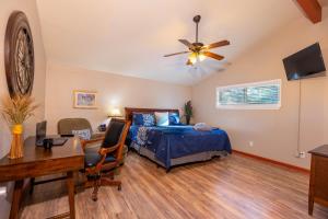 a bedroom with a bed and a desk and a ceiling fan at The Hideout at Hills Haven in Wimberley