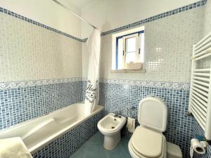 a blue tiled bathroom with a toilet and a sink at Casa da Horta in Canha +23 photos