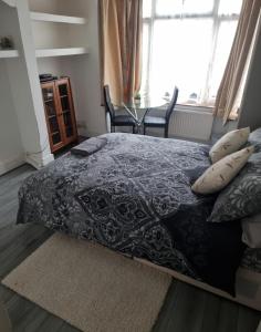 um quarto com uma cama, uma mesa e uma janela em COZY ROOMS 25 min LIVERPOOL STREET em Londres