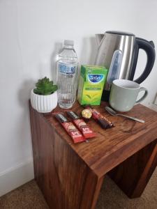a wooden table with food and a bottle of water at COZY ROOMS 25 min LIVERPOOL STREET in London