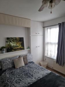 a bedroom with a bed and a window at COZY ROOMS 25 min LIVERPOOL STREET in London