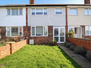 a brick house with a lawn in front of it at Herring House in Lowestoft