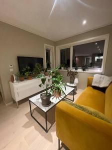 a living room with a yellow couch and a table at Rekkehus sentralt i Bryne in Time