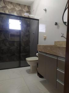 a bathroom with a toilet and a glass shower at Novo Horizontes in São João del Rei