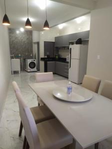 uma cozinha com uma mesa e cadeiras e um frigorífico em Novo Horizontes em São João del Rei