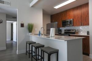 a kitchen with a counter and stools at a bar at Oceanside Beach style King & 2 queen beds in Oceanside