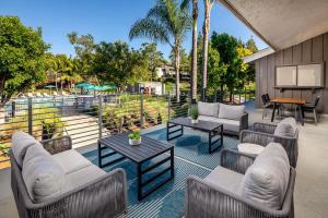 a patio with couches and tables and a pool at Oceanside Beach style King & 2 queen beds in Oceanside