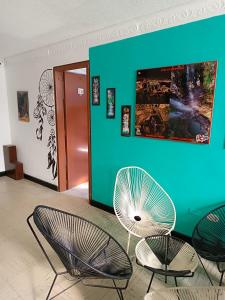 a room with two chairs and a blue wall at Hostel Nirvana San Gil in San Gil