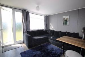 a living room with a couch and a table at Beautiful Chalet close to the beach in Eastchurch