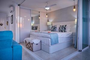 a bedroom with a large bed and a blue chair at Doñana 1021 in Patalavaca +61 photos