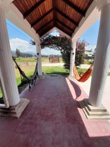 a porch with two hammocks and a view of a field at Villa pinzon in Paipa
