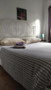 a large white bed with a white headboard in a bedroom at MasRelaxTenerife in Las Lagunas