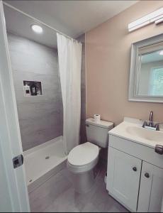 a bathroom with a toilet and a shower and a sink at Guest House Baltimore County in Parkville
