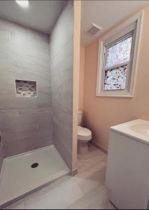 a bathroom with a toilet and a sink and a window at Guest House Baltimore County in Parkville